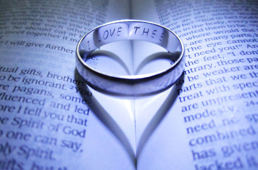 Ring on Bible Symbolizing God Loves His People Like a Groom Loves His Bride