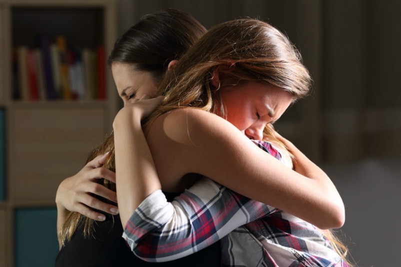 Two Friends Hug As Young Woman Experiences Gods Love, Compassion and Forgiveness